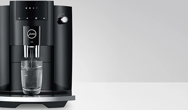 Voor aanzicht van de JURA E4 die heet water tapt.